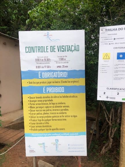 Placa de informação com horários e regras de acesso a Cachoeira da Roncadeira e Escorrega macaco